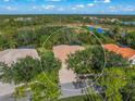 Property's aerial view shows a large house with a pool and a lush green landscape at 790 Shadow Bay Way, Osprey, FL 34229