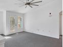 Bright living room with grey carpet and access to balcony at 8932 Manor Loop # 207, Lakewood Ranch, FL 34202