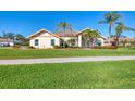 House exterior with palm trees and a spacious lawn at 1144 Hoover St, Nokomis, FL 34275