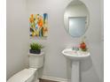 Small bathroom with pedestal sink, toilet, and oval mirror at 13014 Bayberry Way, Parrish, FL 34219