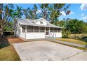 Charming single-story home featuring a screened-in porch and concrete driveway, creating an inviting curb appeal at 1717 32Nd St, Sarasota, FL 34234