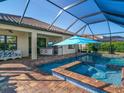 Relaxing pool and spa area with a covered patio and outdoor kitchen at 1748 Still River Dr, Venice, FL 34293