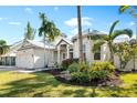 White exterior home with palm trees and manicured landscaping at 1810 Wisteria St, Sarasota, FL 34239