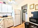 Condo kitchen, white cabinets, appliances, view to hallway at 2075 Canal Dr # L36, Bradenton, FL 34207