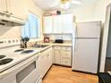 Bright condo kitchen with white cabinets and appliances at 2075 Canal Dr # L36, Bradenton, FL 34207