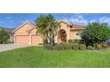 Tan house with tile roof, two-car garage, and tropical landscaping at 4881 Flagstone Dr, Sarasota, FL 34238