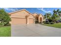 Tan house with tile roof, two-car garage, and manicured lawn at 4881 Flagstone Dr, Sarasota, FL 34238