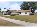 Single-story house with a brown garage door and spacious lawn at 5506 3Rd Avenue W Plz, Bradenton, FL 34209