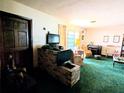 Living room with brick fireplace and green carpet at 5507 28Th W St, Bradenton, FL 34207