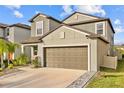 Two-story house with neutral siding, brown garage door, and landscaping at 5546 Appleton Shore Dr, Apollo Beach, FL 33572