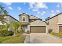 Two-story house with neutral siding, brown garage door, and landscaping at 5546 Appleton Shore Dr, Apollo Beach, FL 33572