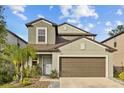 Two-story house with neutral siding, brown garage door, and landscaping at 5546 Appleton Shore Dr, Apollo Beach, FL 33572