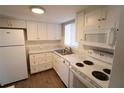 White kitchen with new appliances and wood-look floors at 5893 Welcome Rd # I-7, Bradenton, FL 34207