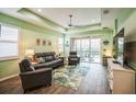 Spacious living room with gray couches, a large TV, and sliding doors to a patio at 5914 Fiore Dr, Bradenton, FL 34208