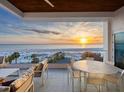 Expansive balcony features comfortable seating and dining with breathtaking sunset views over the Gulf at 6100 Midnight Pass Rd # 401, Sarasota, FL 34242