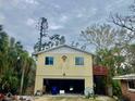 Yellow house with attached garage and upper deck at 7820 Midnight Pass Rd, Sarasota, FL 34242