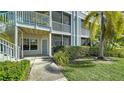 Condo exterior showcasing a walkway, second story balcony, lush landscaping, and a view of the building facade at 850 S Tamiami Trl # 408, Sarasota, FL 34236