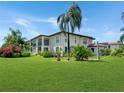 Condo building showcasing manicured lawn and palm trees at 10190 Imperial Point W Dr # 16, Largo, FL 33774