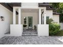 Front entrance with gray door, paver walkway, and white columns at 2174 Mcclellan Pkwy, Sarasota, FL 34239