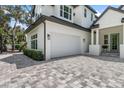 Two-car garage with white doors and paver driveway at 2174 Mcclellan Pkwy, Sarasota, FL 34239
