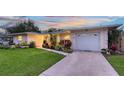 Newly paved driveway leading to a two-car garage with a beautifully landscaped lawn at 2651 Leafy Ln, Sarasota, FL 34239