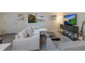 Bright living room features a sectional sofa, large TV, and wood-look floors at 3751 S School Ave # 11, Sarasota, FL 34239