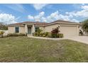 Tan house with brown roof, landscaping, and a two-car garage at 4352 Adelaide Ave, North Port, FL 34288