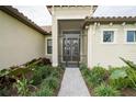 Front entrance with a screened porch and landscaped walkway at 4814 Sparkling Sea Ln, Lakewood Ranch, FL 34211