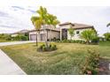 House exterior with palm trees, landscaping, and paver driveway at 4814 Sparkling Sea Ln, Lakewood Ranch, FL 34211