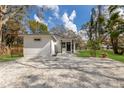 Home exterior featuring a gravel drive, manicured lawn, mature landscaping and black trim at 5429 Potter St, Sarasota, FL 34232