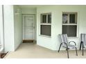 Small front porch with white door and two chairs at 5725 Greenwood Ave # 9103, North Port, FL 34287