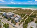 Aerial view of beachfront property showcasing a modern home near the ocean and other buildings at 600/602 Beach Rd # 1 & 2, Sarasota, FL 34242