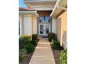 Front entry with double doors, light fixture, and landscaping at 636 Lakescene Drive Dr, Venice, FL 34293