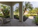 Relaxing covered patio with brick pavers, comfortable seating, and tranquil garden views at 7817 Passionflower Dr, Sarasota, FL 34241