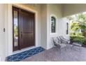 Welcoming front porch with stylish seating and a dark wood door at 7817 Passionflower Dr, Sarasota, FL 34241