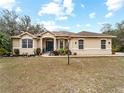 Tan house with blue front door and landscaping at 8107 High Oaks Trl, Myakka City, FL 34251