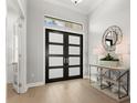 Bright and airy entryway with double doors, wood floors and console table at 9020 Artisan Way, Sarasota, FL 34240