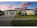 Charming single-story home with a three-car garage under a dramatic sunset sky at 9020 Artisan Way, Sarasota, FL 34240