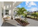 Relaxing front porch with paver patio, palm trees and seating area at 9020 Artisan Way, Sarasota, FL 34240