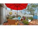 Inviting patio with red umbrella, table, and chairs at 919 Waterside Ln, Bradenton, FL 34209