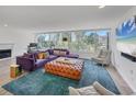Bright living room with large windows, stylish furniture, and hardwood floors at 100 Sands Point Rd # 323, Longboat Key, FL 34228
