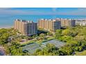 Aerial view of luxury beachfront condo building with tennis courts at 1211 Gulf Of Mexico Dr # 603, Longboat Key, FL 34228