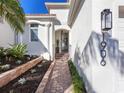 Brick walkway leads to a charming home entry with wrought iron gate at 1906 Harbour Links Cir # 14, Longboat Key, FL 34228
