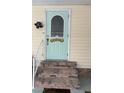 Inviting light teal front door with a brick staircase at 2107 Palma Sola Blvd # 27, Bradenton, FL 34209