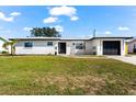 Newly renovated home with a modern exterior and lush lawn at 240 Algiers Dr, Venice, FL 34293