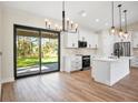 Modern kitchen with white cabinets, island, and stainless steel appliances at 4497 N Salford Blvd, North Port, FL 34286