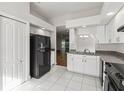 Bright kitchen with white cabinets, black appliances, and tile floor at 4534 Fern Dr, Bradenton, FL 34208