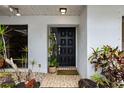 Black front door with tiled entryway and potted plants at 5575 Beneva Woods Cir, Sarasota, FL 34233