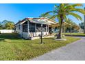 Single-wide mobile home with covered porch, palm tree, and well-maintained lawn at 808 53Rd E Ave # 226L, Bradenton, FL 34203