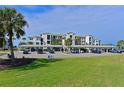 Condo building exterior showcasing covered parking and landscaping at 1030 Tidewater Shores Loop # 306, Bradenton, FL 34208